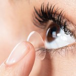 Contact lens being inserted onto eyeball.